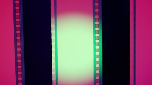 Vertical Film Strip on a Pink Background with Green Circular Light Close Up 35Mm Film Slide Frame