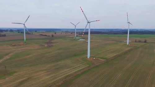 Drone, aerial video of four electric windmills - forward and upward movement