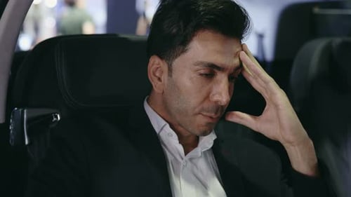 Intense Man Sits in Car Thinking