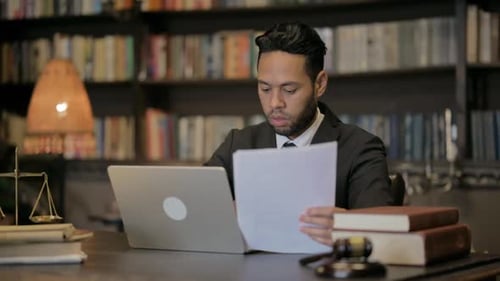 Man in Suit Reviews Legal Documents at Desk