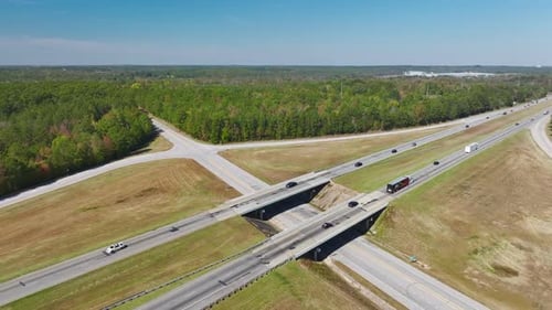 View From Above of Busy American Highway with Fast Moving Traffic Between Woods Interstate