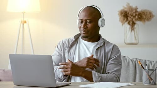 Man At Desk With Laptop Wearing Headphones