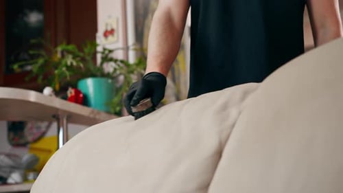 Close Up Professional Cleaning in an Apartment the Cleaner Cleans a Textile Sofa with a Brush and