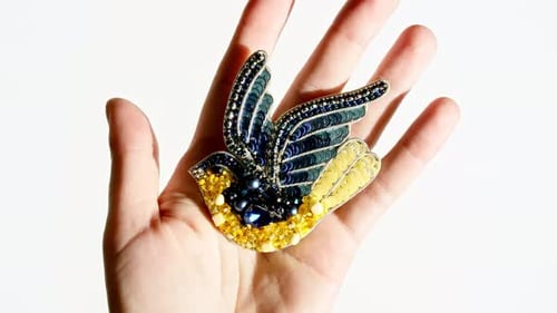 Beaded Bird Brooch in Hand on White