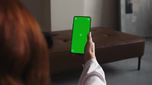 Caucasian Young Woman Holds Phone with Empty Green Screen in Vertical Mode App Advertising No Touch