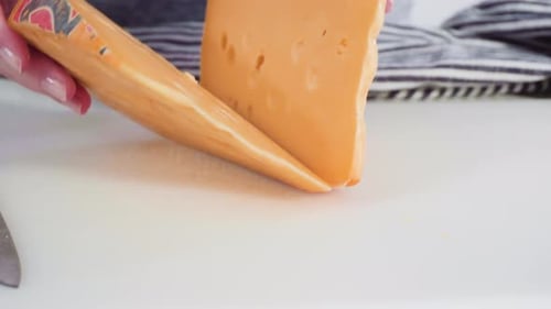 Large Slice of Semi Soft Part Skim Cheese on a White Cutting Board