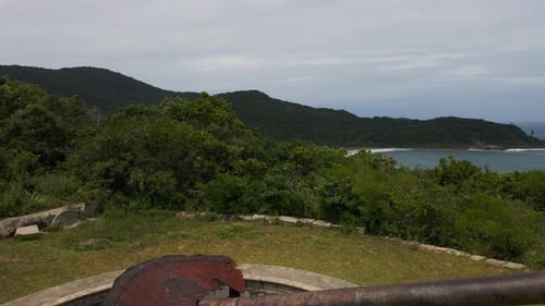 Rusted Cannon Overlooking the Beach and Lush Coastline