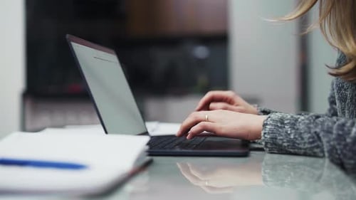 Woman Typing on Laptop at Home Desk