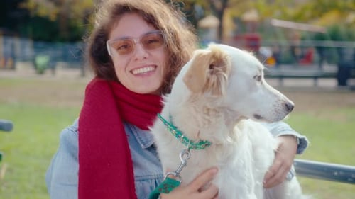 Portrait of Joyous Woman Hugging Dog in the Park