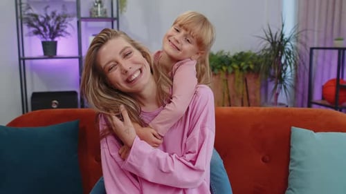 Happy Woman and Child Hugging on Couch