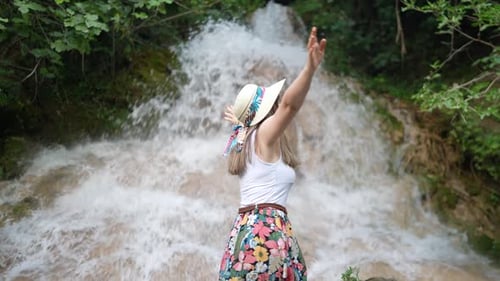 Woman Enjoys Waterfall View in Nature