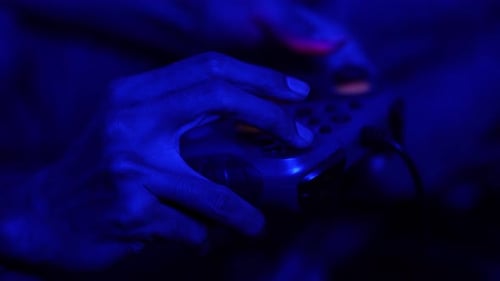 Immersive Gaming Moment – Close-Up of Controller Grip in Blue Glow