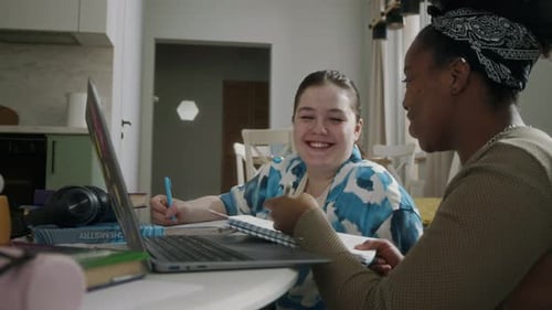 Two Smiling Students Studying Together at Home
