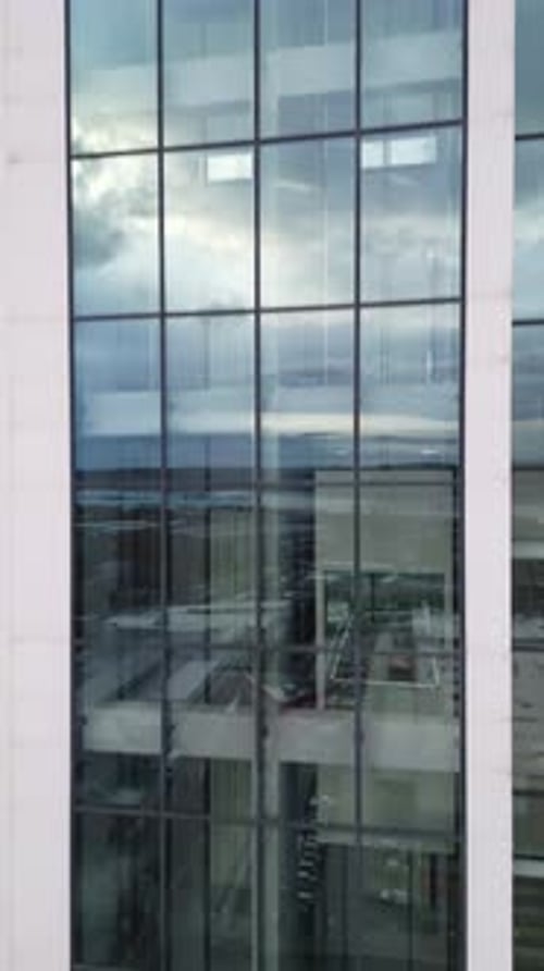 Aerial View of Moving Elevator Walls and Windows of Contemporary Business Center at Evening