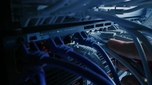 Makroaufnahme: Der IT-Administrator steckt den RJ45-Internetanschluss in den LAN-Router-Switch ein. Informationen C