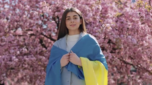 Woman Holding Ukrainian Flag While Standing Outdoors