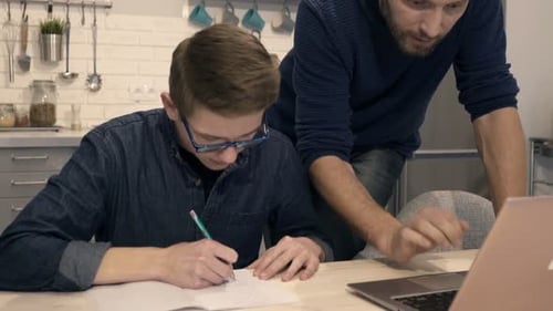Teen Working on Homework with Assistance from Adult