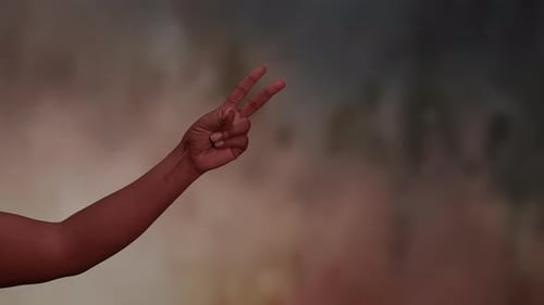 Arm Making Peace Sign Against Abstract Background