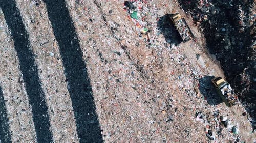 Große Müllkippe und Müllwagen mit Müll in Luftaufnahme von oben