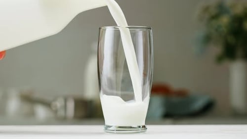 Milk Pouring in Glass Cup Closeup Glass with Yogurt Dairy Products Concept Drinking Fresh
