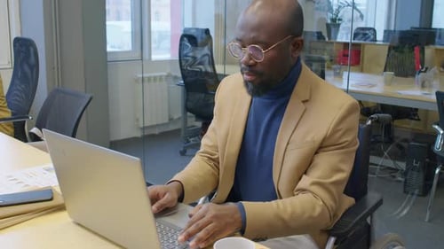 Male Office Manager with Disability Working in Laptop
