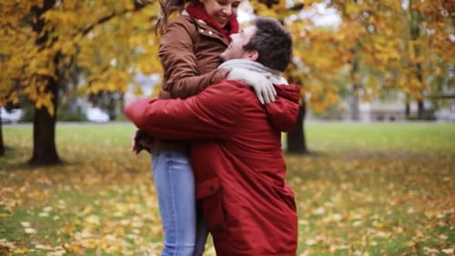 Happy young couple meeting and spinning in beautiful autumn park