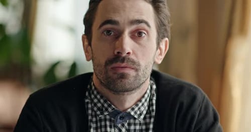 Thoughtful Man Looking at Camera Indoors