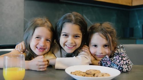 In einer modernen Küche naschen Kinder gerne an Keksen und nippen an Saft, wodurch ein warmes Gefühl entsteht