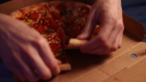 Hands Taking Slice of Pepperoni Pizza