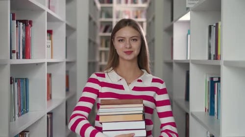 Young Woman Smiling with Books in Library
