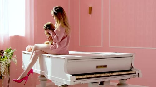 Woman with Dog on White Piano in Pink Room