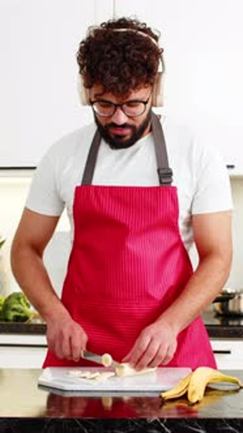 Man in Apron Dances and Cuts a Banana