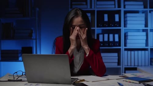 Businesswoman seriously stressed working overtime headache and eye ache due to office syndrome