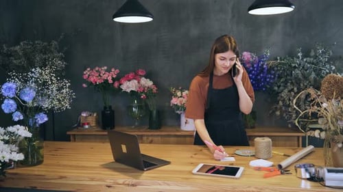 Woman Florist in a Flower Shop Takes an Order By Phone Call the Bouquet Customer to Discuss the