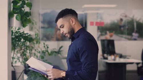 Businessman Reading Paperwork in Office 2024 Years