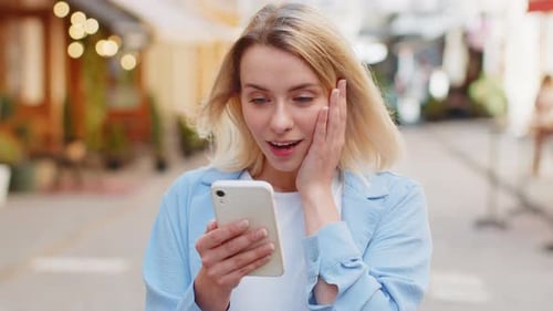 Woman Surprised by Good News on Smartphone