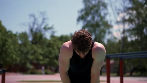 portrait of young sweaty tired fitness athlete or bodybuilder after training outdoors on sports