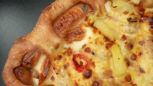 Eine Käsepizza mit Wurst im Makro-Nahaufnahmevideo. 4K.
