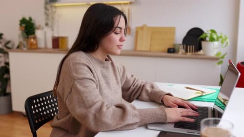 Jeune adolescente heureuse apprenant en ligne à l'aide d'un ordinateur portable à la maison