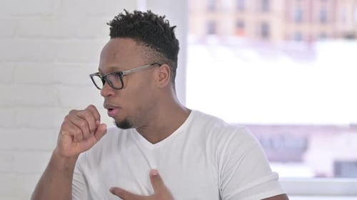 Man Coughing with Hand on Chest Indoors