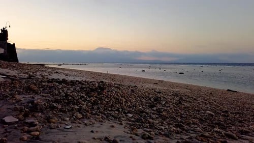 Timelapse sunset over sea, beach and ocean blue background with mountains and clouds. Bali Indonesia