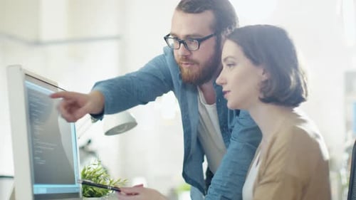 Teamwork: Man and Woman Working Together at Computer