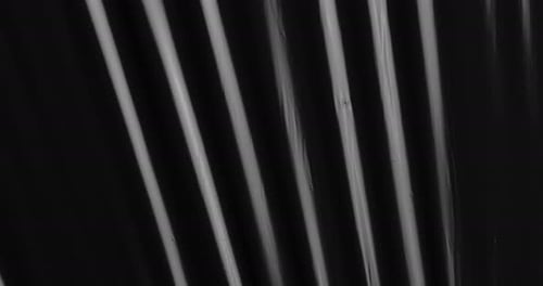 Betreten Sie ein Reich faszinierender Texturen, während gestreckte Plastikfolie auf schwarzem Hintergrund tanzt