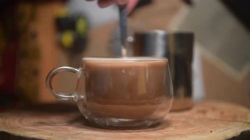 Coffee Drink Being Stirred in Clear Glass Mug