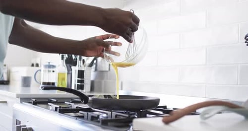 Person Cooking an Egg in Modern Kitchen