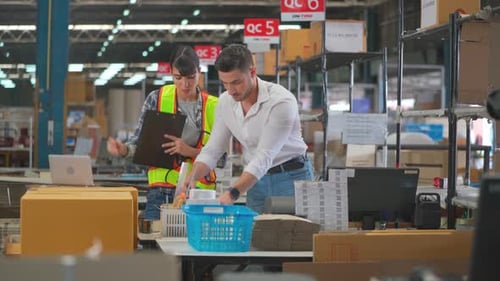 Zwei Lagerarbeiter verpacken die Produktverpackung an der Theke der Produktionslinie