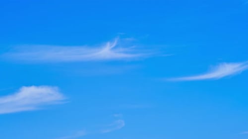 Smoothly flowing white clouds on a blue blue sky, time lapse