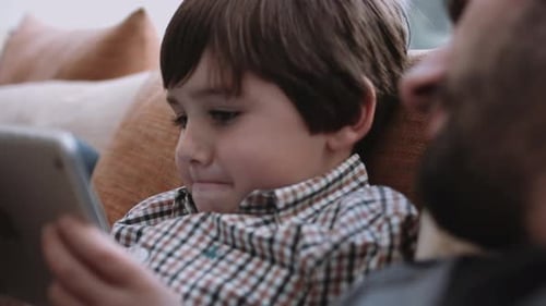 Father and Son Relaxing with a Tablet Indoors
