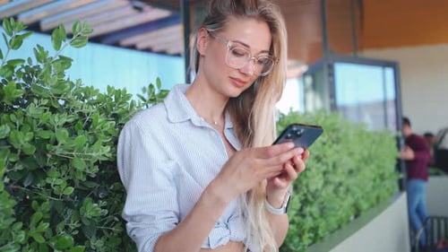 Woman Using Phone in Urban Setting