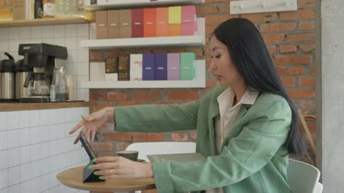 Elegant Young Asian Sipping Coffee During Video Meeting At Cafe